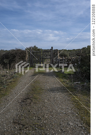 Rustic wooden gate with dry stone wall in a rural countryside 122108888
