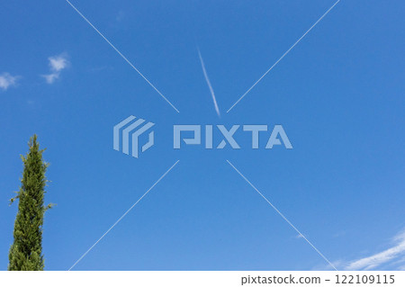 A fuzzy high-flying passenger plane and white streaks on a blue sky A fuzzy high-flying passenger plane and white streaks on a blue sky 122109115