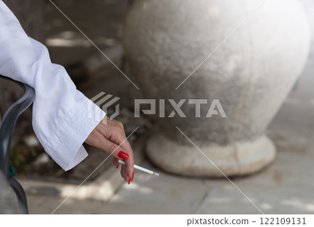 Woman Holding a Cigarette with Red Nails Woman Holding a Cigarette with Red Nails 122109131