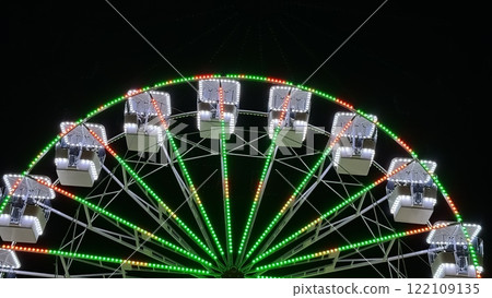 A brightly illuminated Ferris wheel against the night sky 122109135