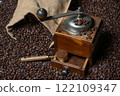 Rustic coffee grinder with a measuring spoon stand with a bag of coffee on a background of coffee beans 122109347