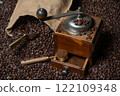 Rustic coffee grinder with a measuring spoon and a bag of coffee with a coffee scoop on a background  of coffee beans 122109348