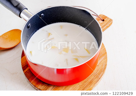 製作 Aligot:牛奶和配料放入鍋中 製作 Aligot:牛奶和配料放入鍋中 122109429