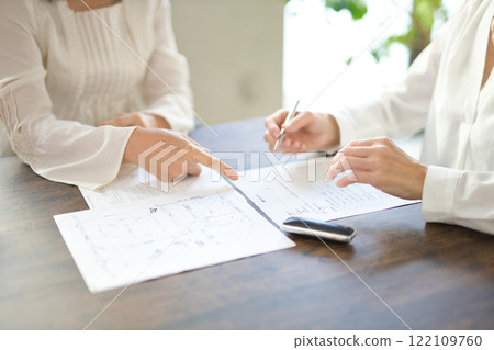 簽署房地產合約的兩名婦女的手 122109760