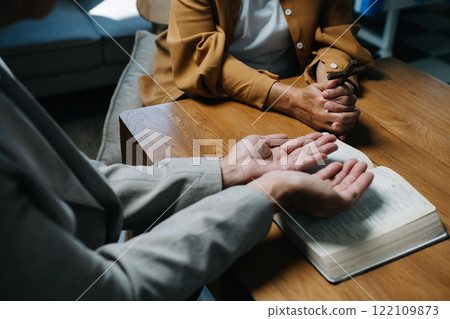 Men and women praying to God with the Bible, seeking blessings and guidance.  heartfelt depiction of faith, devotion, and spiritual connection. 122109873