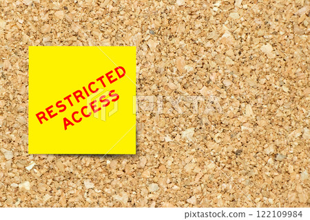 Yellow note paper with word restriced access on cork board background with copy space 122109984