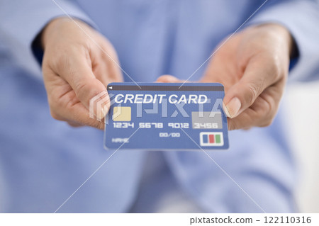 Middle-aged woman handing over a credit card 122110316