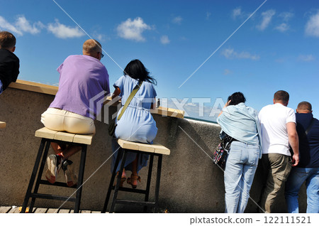 people are sitting on the embankment and watching the Baltic Sea in the city of Svetlogorsk people are sitting on the embankment and watching the Baltic Sea in the city of Svetlogorsk 122111521
