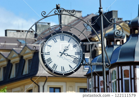a clock in a forged frame on a building in the city of Zelenogradsk a clock in a forged frame on a building in the city of Zelenogradsk 122111579