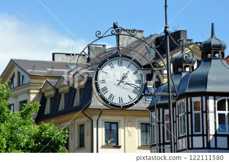 a clock in a forged frame on a building in the city of Zelenogradsk 122111580
