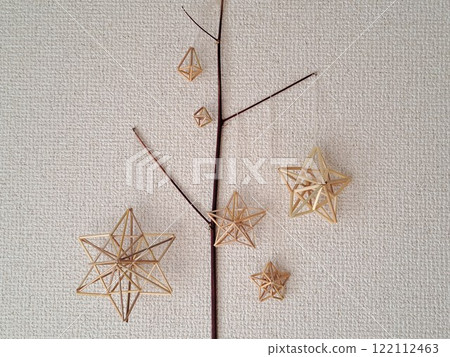 Scandinavian handicraft Himmeli, handmade from natural rye straw, laid out on tree branches 122112463