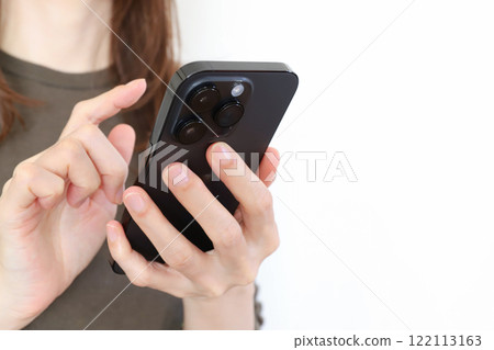 Hands of a woman using a smartphone 122113163