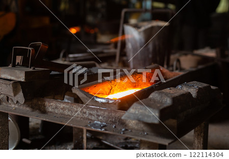 Mold with molten metal in the foundry workshop of metallurgical plant 122114304