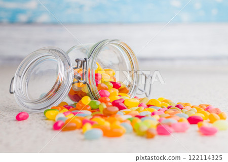 Multicolored jelly beans with various flavors in jar on kitchen table. Multicolored jelly beans with various flavors in jar on kitchen table. 122114325