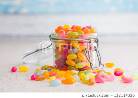 Multicolored jelly beans with various flavors in jar on kitchen table. 122114326