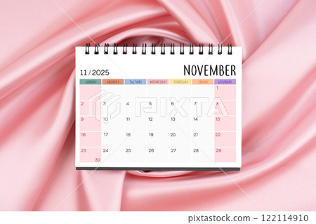 November 2025 desk calendar on pink color silk textile background, Flat lay. November 2025 desk calendar on pink color silk textile background, Flat lay. 122114910