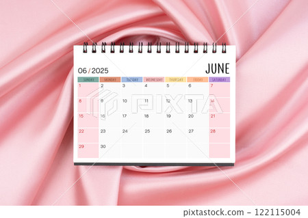 June 2025 desk calendar on pink color silk textile background, Flat lay. 122115004