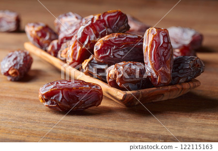 Dates fruits in a wooden dish. Dates fruits in a wooden dish. 122115163
