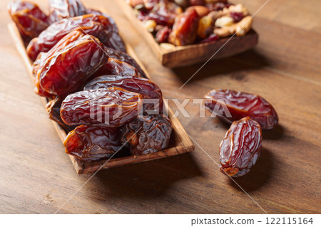 Dates fruits in a wooden dish. 122115164