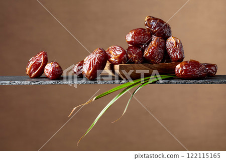 Closeup of sweet dates in wooden dish. 122115165