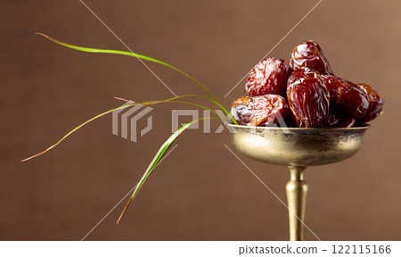 Closeup of sweet dates in brass dish. Closeup of sweet dates in brass dish. 122115166