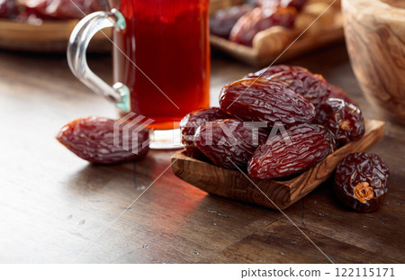 Tea and dates on a old wooden table. 122115171