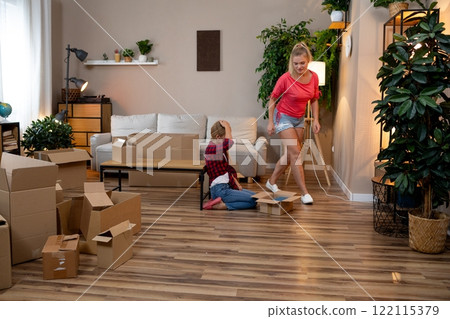 A Busy Family Unpacking Boxes Together in Their Cozy and Inviting Living Room Space 122115379