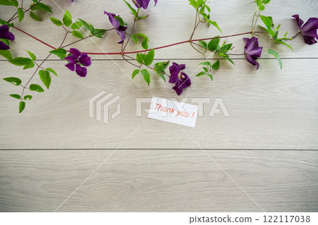 branch of blooming purple clematis, on a light wooden table branch of blooming purple clematis, on a light wooden table 122117038