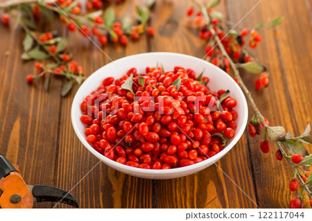 fresh ripe red goji berries in a bowl on a wooden table fresh ripe red goji berries in a bowl on a wooden table 122117044
