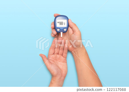Person holding a blue blood sugar monitor Person holding a blue blood sugar monitor 122117088