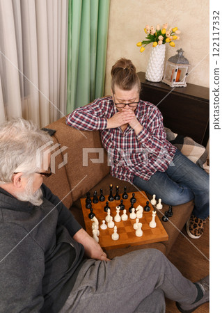 An elderly couple playing chess An elderly couple playing chess 122117332