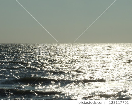 silver sea waves with sun path on surface and smooth horizon against clear sky, seascape without people and ships on sunny cold day, empty sea space background silver sea waves with sun path on surface and smooth horizon against clear sky, seascape without people and ships on sunny cold day, empty sea space background 122117701