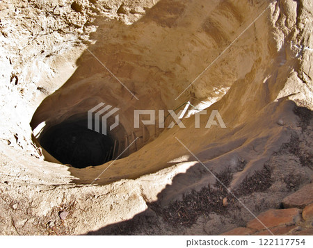 Dried up water well in desert. Yellow texture of sandstone and rope ladder. Round hole in ground. Dried up water well in desert. Yellow texture of sandstone and rope ladder. Round hole in ground. 122117754