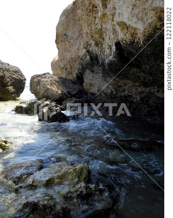 Rocky Desert Shore Along the Red Sea With Gentle Waves and Sunlit Cliffs in the Background 122118022