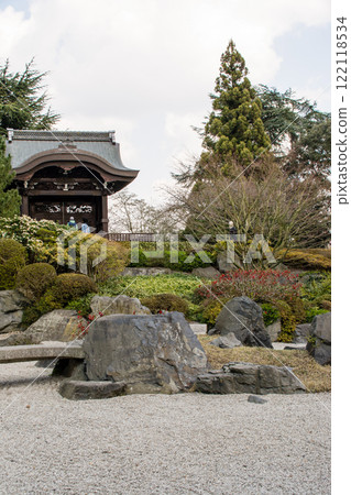 A Japanese garden surrounded by trees including a rock garden and an Imperial Gate at Kew Gardens in the outskirts of London 122118534