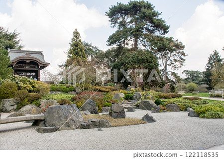 A Japanese garden surrounded by trees including a rock garden and an Imperial Gate at Kew Gardens in the outskirts of London 122118535