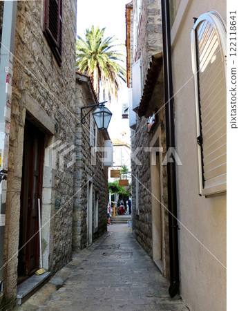 Narrow street in the old medieval town of Budva with Venetian Mediterranean architecture. Windows with shutters and shutters, street masonry 122118641