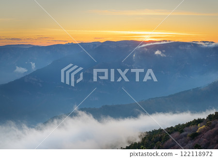 Misty mountains and clouds create a magical atmosphere against the dawn light 122118972