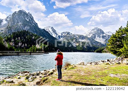 Woman in red coat at the Sant Maurici lake in the snow, in the Aigues Tortes National Park, in the Pyrenees of Lleida, Catalonia, Spain Woman in red coat at the Sant Maurici lake in the snow, in the Aigues Tortes National Park, in the Pyrenees of Lleida, Catalonia, Spain 122119042