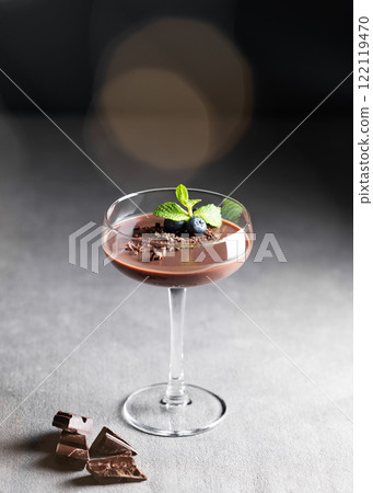 Chocolate pudding in a tall glass with mint  and fresh blueberry on a dark background 122119470