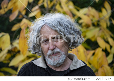 Pensive elder amidst golden autumn foliage 122119746