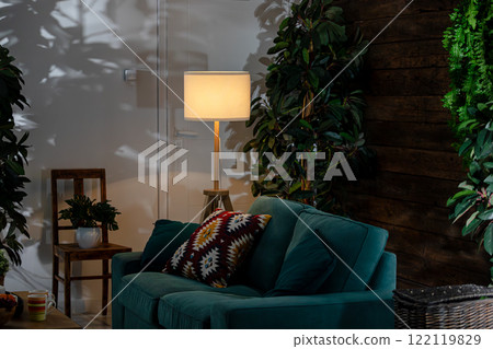A Stylish Living Room Featuring a Cozy Sofa Surrounded by Lush Greenery and Inviting Decor 122119829