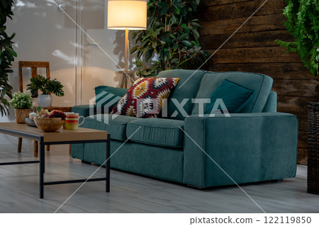 A Cozy Living Room Featuring a Stylish Sofa Surrounded by Beautiful Greenery and Decor 122119850