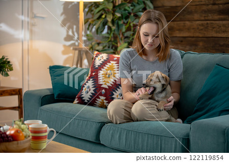 A Cozy and Heartwarming Moment Spent with an Adorable Puppy while Relaxing on the Couch A Cozy and Heartwarming Moment Spent with an Adorable Puppy while Relaxing on the Couch 122119854