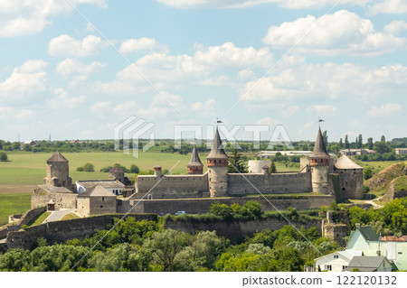 Historic medieval castle with towers under a blue sky and green surroundings Historic medieval castle with towers under a blue sky and green surroundings 122120132