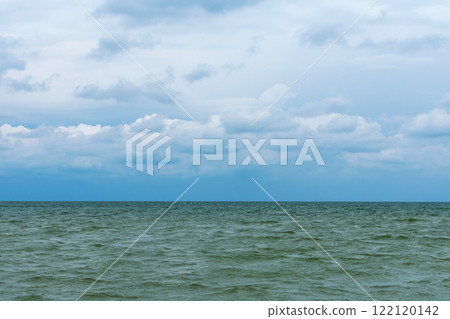 Calm ocean view under a cloudy sky showcasing tranquility and open water Calm ocean view under a cloudy sky showcasing tranquility and open water 122120142