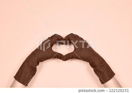 Working hands in rubber protective gloves show the heart. Working hands in rubber protective gloves show the heart. 122120231