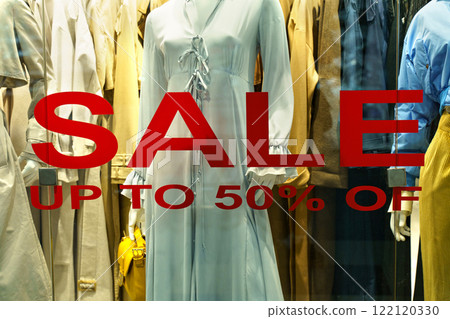 Vibrant display highlights elegant clothing with bold sale signs 122120330