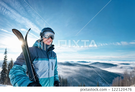 Winter Sports Enthusiast with Ski Equipment on a Scenic Mountain Slope Winter Sports Enthusiast with Ski Equipment on a Scenic Mountain Slope 122120476