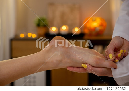 Experience a relaxing foot massage in a calming spa with aromas, candles, and serenity Experience a relaxing foot massage in a calming spa with aromas, candles, and serenity 122120682